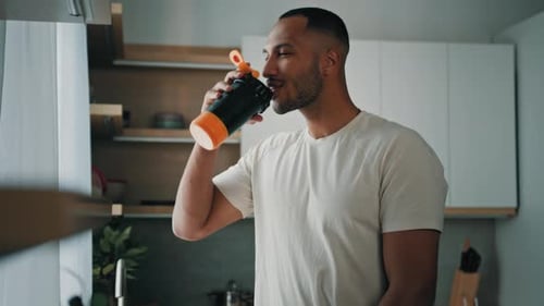 Fit Man Drinking Water after Workout at Home