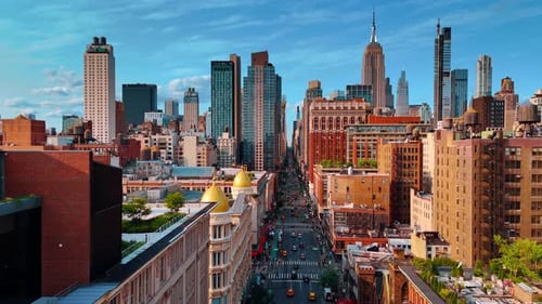 Plenty of cars ride by the wide multi-lane street of New York, USA.