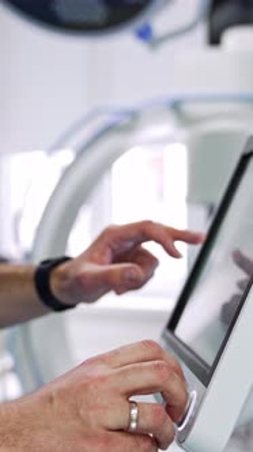 Unrecognized doctor switching on the equipment in modern surgical theatre.