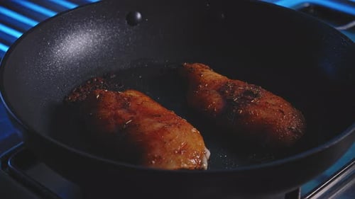 Chicken Breasts Frying in a Skillet on the Stove
