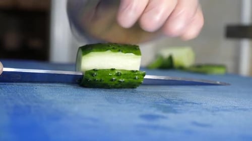 206q. Couper le concombre au couteau. Cuisiner des plats à base de concombre.