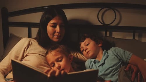 Mother Reading Bedtime Story To Children At Night