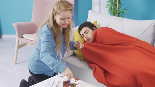 Caring Woman Giving Medicine to Sick Man