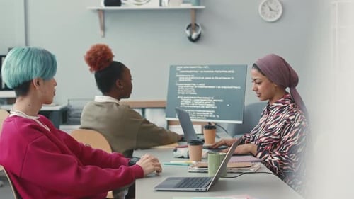 Equipe jovem e diversificada de especialistas em TI trabalhando no escritório