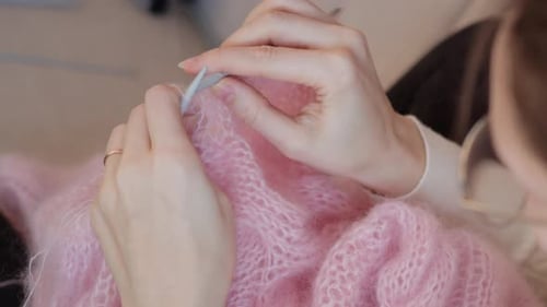 Close Up of Hands Knitting Fluffy Pink Yarn