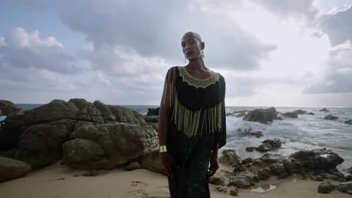 Trans Multiracial Model Poses at Scenic Seaside Location Faces Camera Nonbinary Black Person in