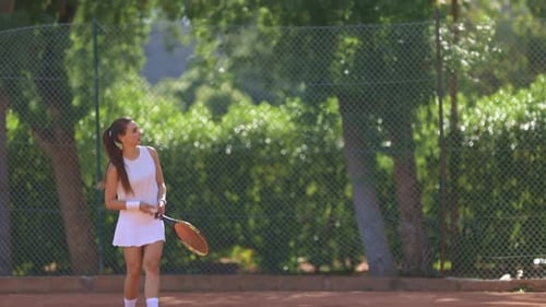 A Young Girl is Playing Tennis on a Court