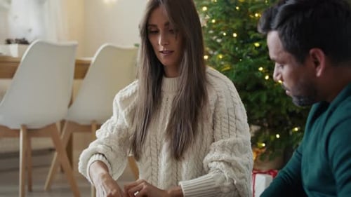 Couple Wrapping Christmas Gifts Together at Home