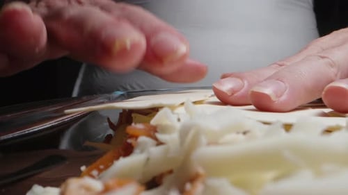 The cook puts the dough sheets on the lasagna, on top of the cheese. extreme close-up.