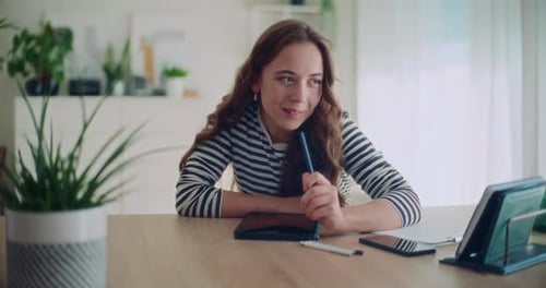 Woman Works on Tablet at Sunny Home Desk