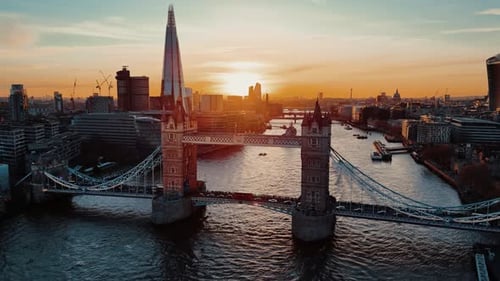 Drone Circling Shot of Traffic on Tower Bridge with Boats on the Thames at Sunset, London