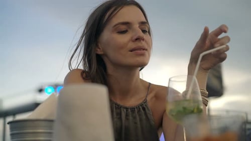 Happy, Young Woman Drinking Cocktail Sitting in Cafe 30s