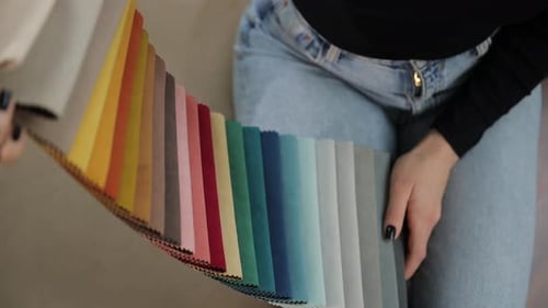 Close Up of Hands Checking Fabric Swatches for Sofa in Furniture Showroom