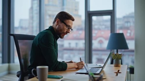 Creative Startuper Writing Papers Working on Project at Office Laptop Closeup