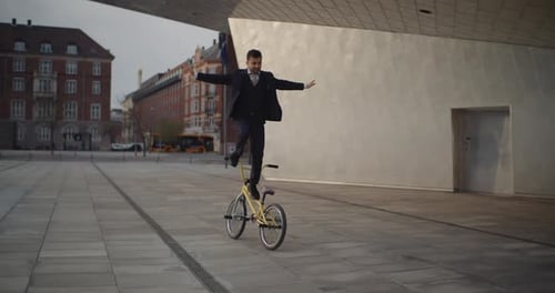 Man in Suit Balances on Bicycle in City