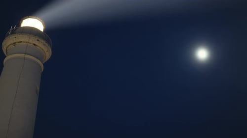 Lighthouse Beam in the Night Near the Full Moon