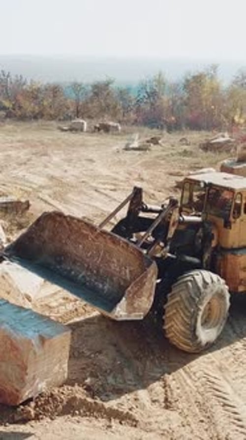 bulldozer amarillo profesional con un balde está trabajando en la cantera con piedras