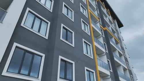 Aerial Video Modern Building Facade with Cloudy Sky in the Background Perfect for Scenic Views