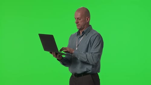 Rechenzentrumstechniker verwendet Laptop gegen grüne Chroma-Key-Wand