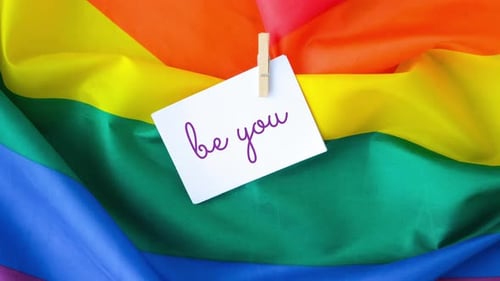 Zoom in Out Rainbow Flag with Text BE YOU Message on Paper Note