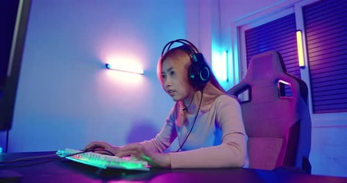 Excited Young Woman Gaming at Computer at Home