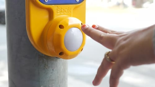 Une mère et son enfant appuient sur le bouton Crossing Signal