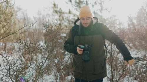 Photographer Walking in Snowy Winter Forest
