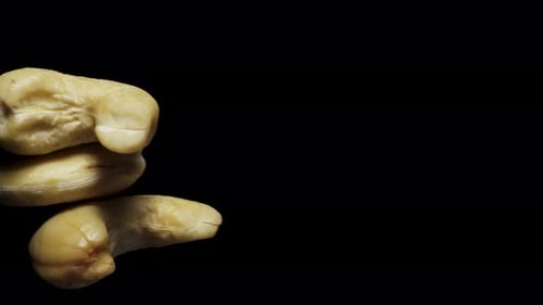 cashew nuts rotate, on a black background close-up. In move