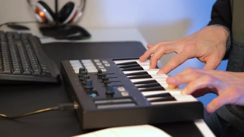 Man Plays MIDI Keyboard on a Desk