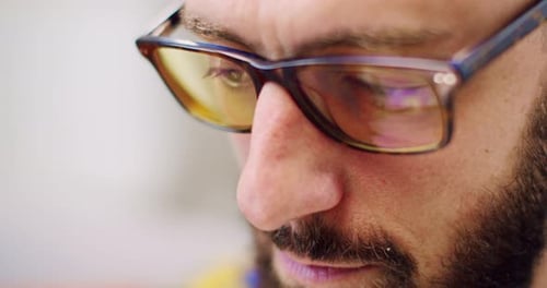 Close Up of Caucasian Young Man in Glasses and with Beard Looking at Screen of Laptop While Using It