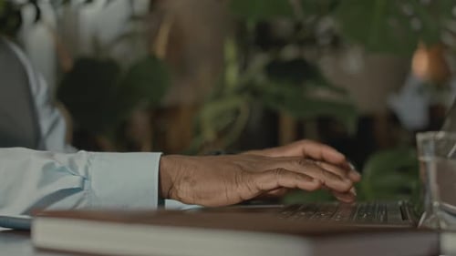 Hands Typing on Laptop Keyboard in Office