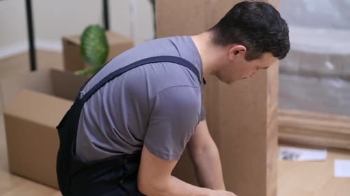 Möbelreparaturfirma im Overall hämmert winzige Nägel