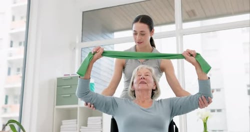 Woman Assists Senior with Resistance Band Exercise
