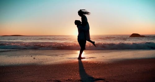 Sunset, love and couple hug at a beach with kiss, support or lifting in celebration in nature