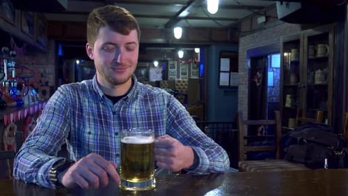 Young Man Joyfully Cheers with Bartender at a Lively Pub