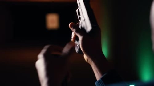 Man at Firing Range Location Loading Pistol with Ammunition Close Up