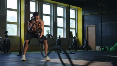 Man Battling Ropes During Intense Gym Workout