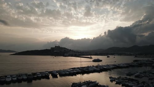 Le Drone survole un port avec des nuages sombres en arrière-plan à Ibiza, Espagne (images aériennes)