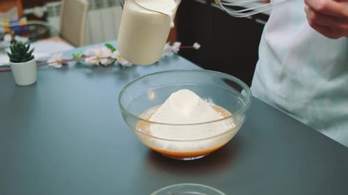 Pouring Milk into Flour for Baking at Home