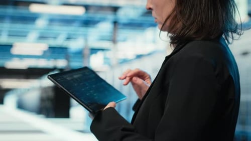 Data Center Programmer Coding on Tablet Optimizing Equipment Rigs