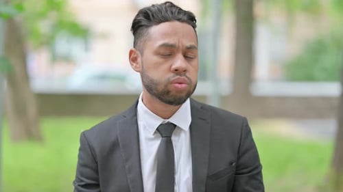 Young Adult in Suit Looking at Watch Outdoors