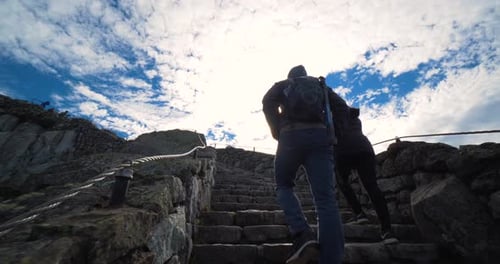 Couple hiking rock steps up mountain in lake placid New York with lens flare