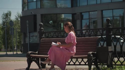 Woman Drawing on Park Bench on Sunny Day