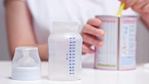 Mother Prepares Food Fusion for Baby in Transparent Bottle