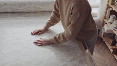 Craftswoman Preparing Fabric in Sunlit Sewing Studio