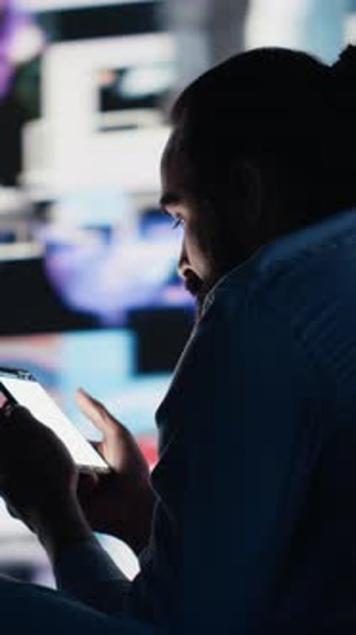 Man Scrolls Through Phone at Night in Dark Room