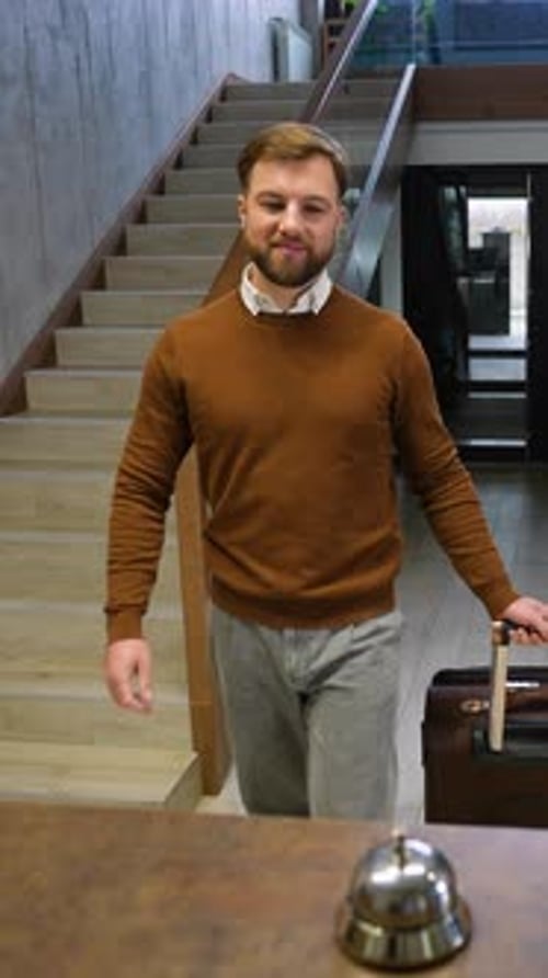 Businessman with Luggage Arriving and Checking in at the Hotel Reception