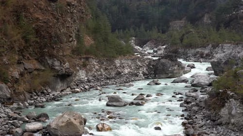A river filled with glacier water in the mountains of the Himalaya Mountain Range.