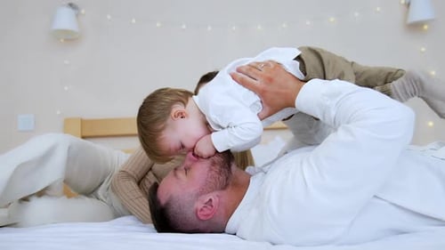 Father and Baby Playing Together on Bed