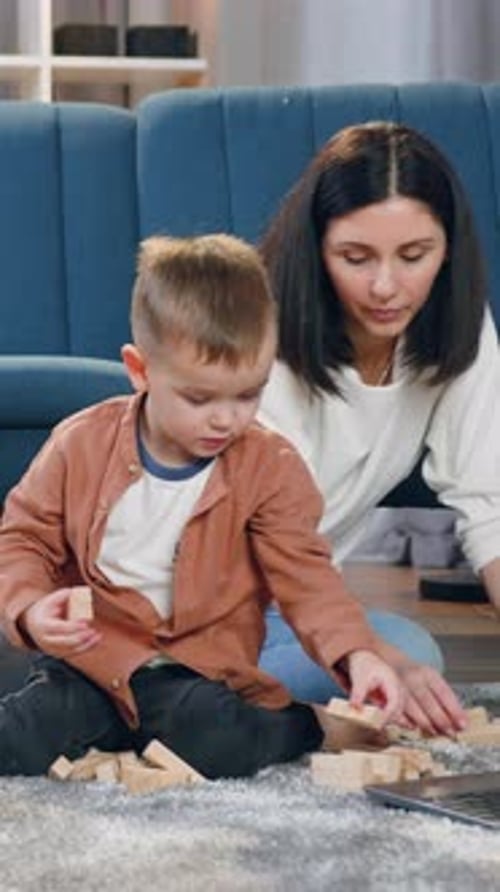 Young Boy and Woman Building Blocks on Rug